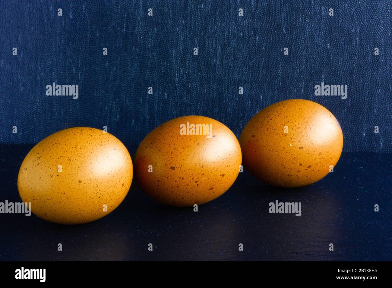 Tree yellow ester eggs on dack blue background Stock Photo
