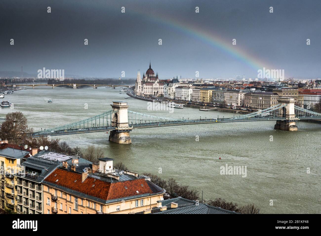 Chain Bridge over Danube in Budapest with Hungarian Parliament and a rainbow in Budapest Stock Photo
