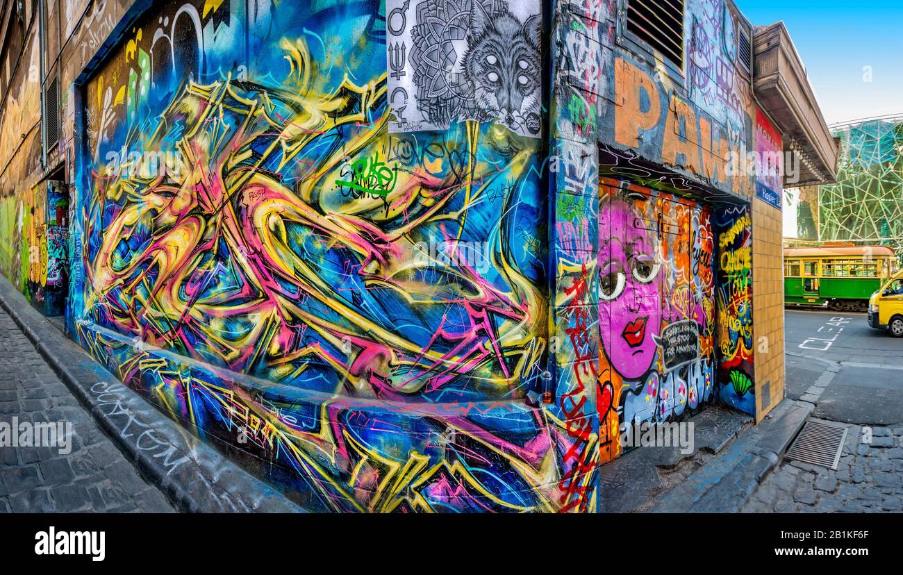 Cobbled back alley , bright coloured graffiti, with tram and Federation Square in background, Hosier Street, Melbourne Lanes, Melbourne, Victoria, Aus Stock Photo