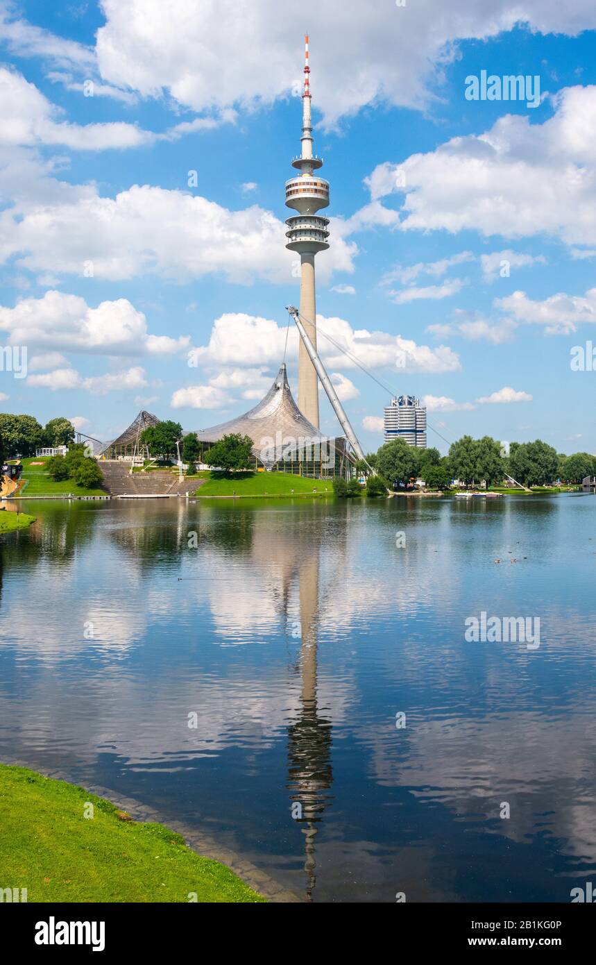 Munich, Germany – July 1, 2016. View of Olympic Tower (Olympiaturm) with reflections in  Olympiasee pond in Olympic park in Munich, Germany, on a sunn Stock Photo
