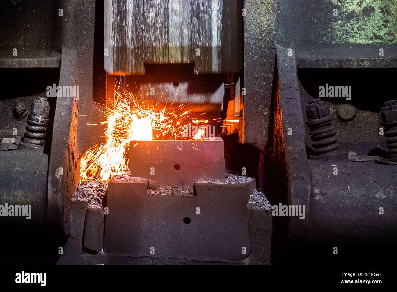 close-up frontal view of hot steel forging process with big mechanical ...