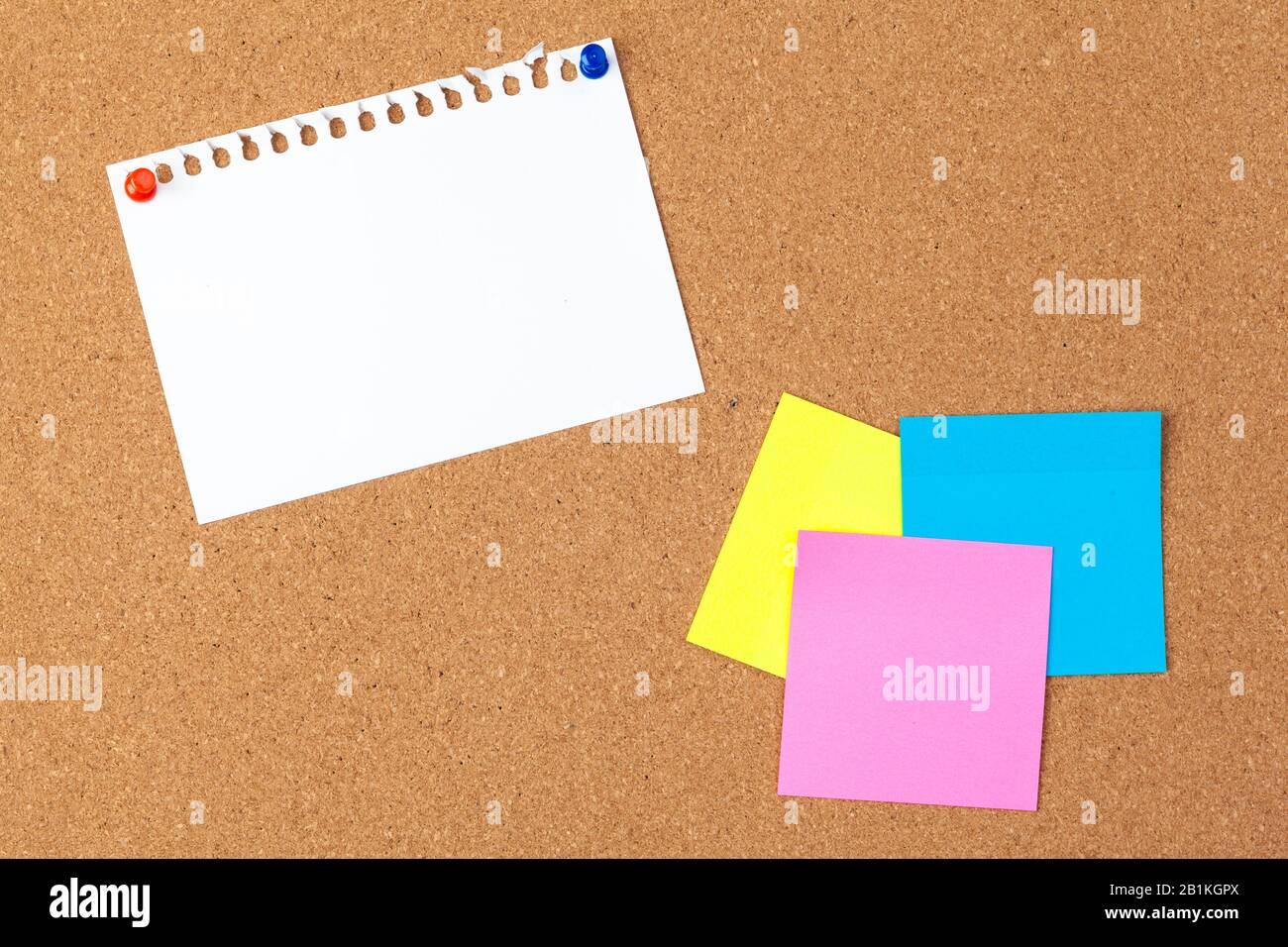 Cork board with several colorful blank notes with pins Stock Photo