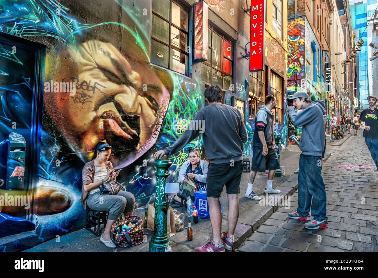 Young people and graffiti artsts, hanging out together down cobbled stone alley way, Hosier Street, Melbourne Lanes, Melbourne, Victoria, Australia Stock Photo