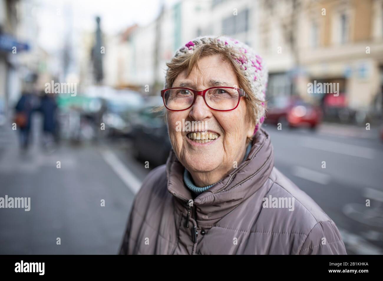 Senior citizen with glasses and cap, portrait in the city, Cologne, North Rhine-Westphalia, Germany Stock Photo
