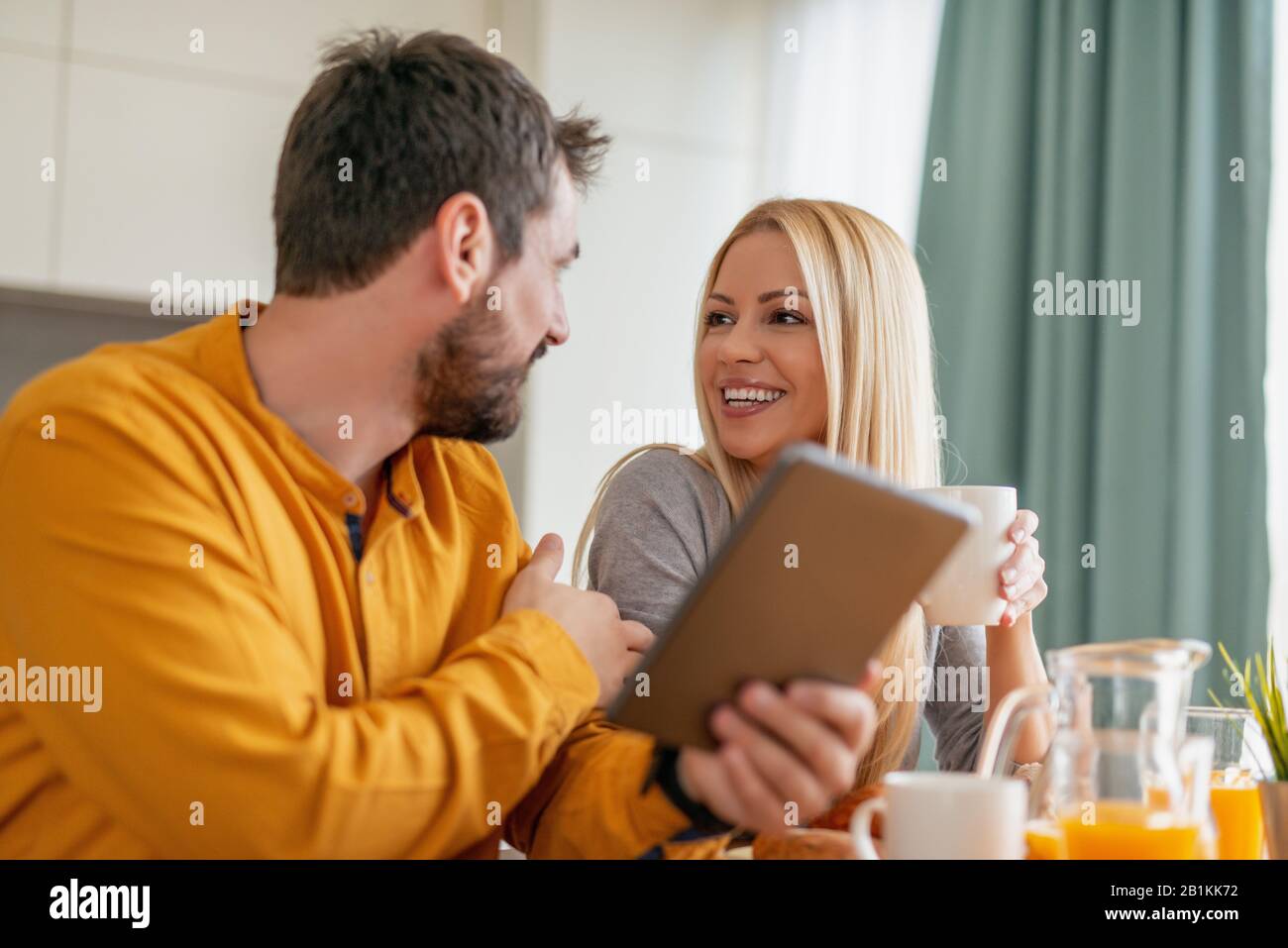 Young couple relaxing at home with cup of coffee.Spending nice time together.Young couple in the morning at home. Stock Photo