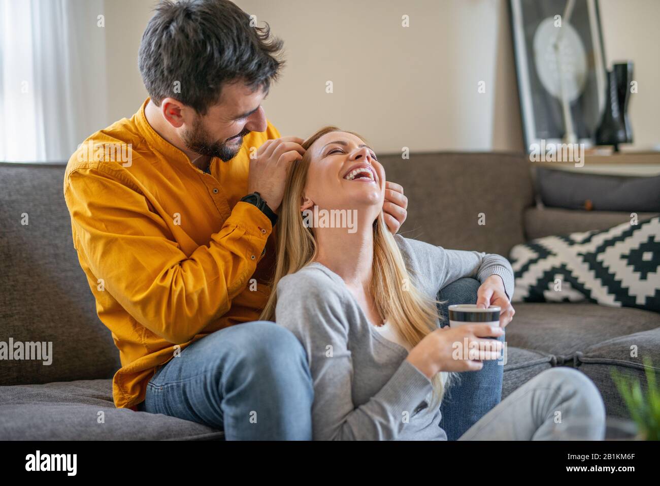 Young couple relaxing at home with cup of coffee.Spending nice time together.Young couple in the morning at home. Stock Photo