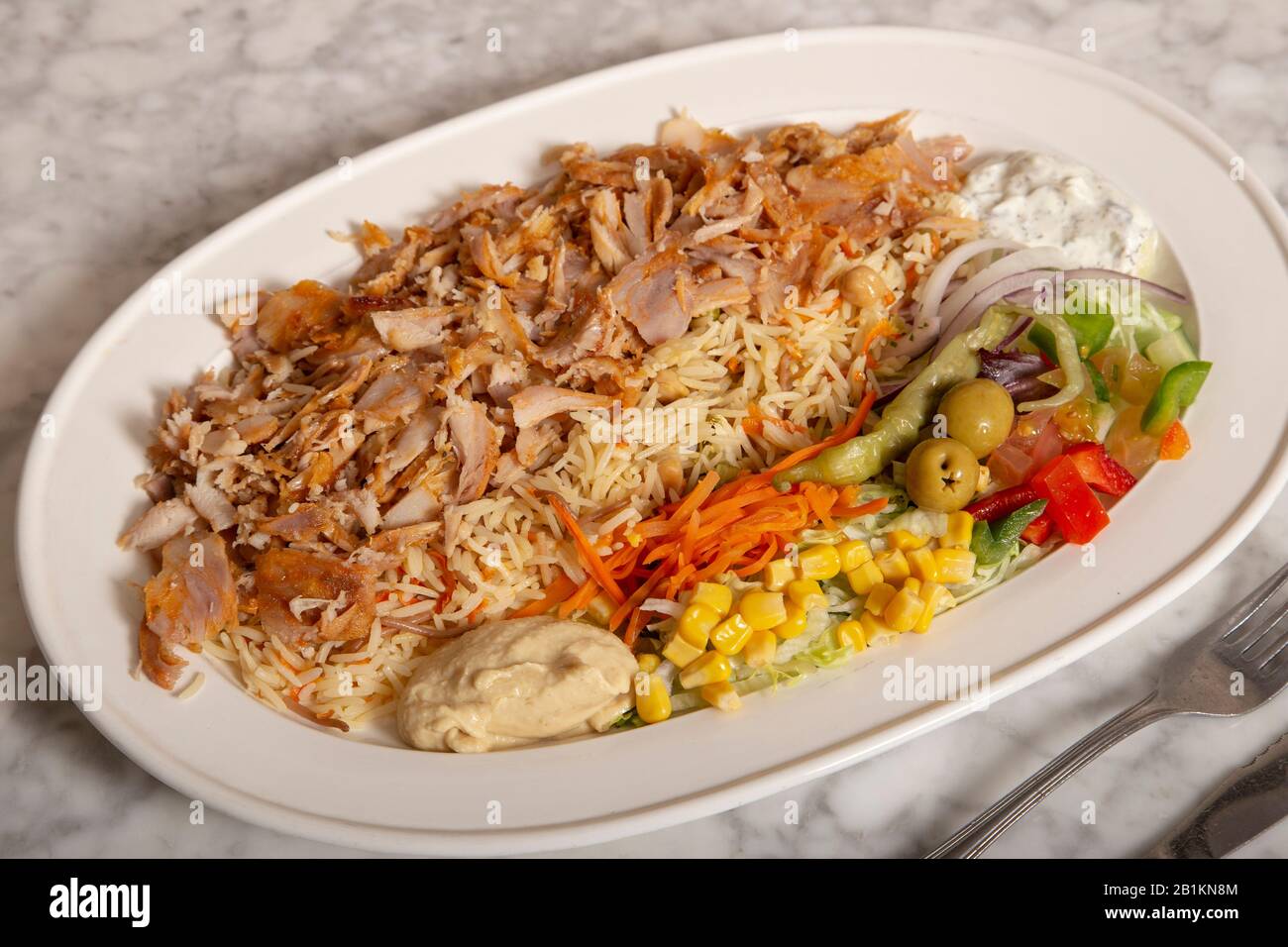 Turkish food dish. Rice with meat Chicken kebab, hummus fries and salad. Stock Photo