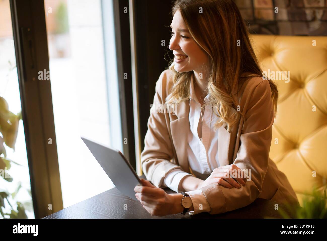 Smiling charming young woman with digital tablet sitting in cafe Stock ...
