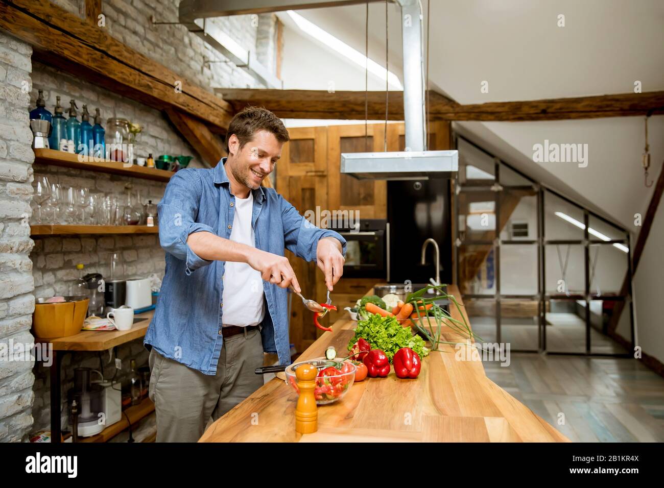 Young man preparing food in the rustic kitchen Stock Photo