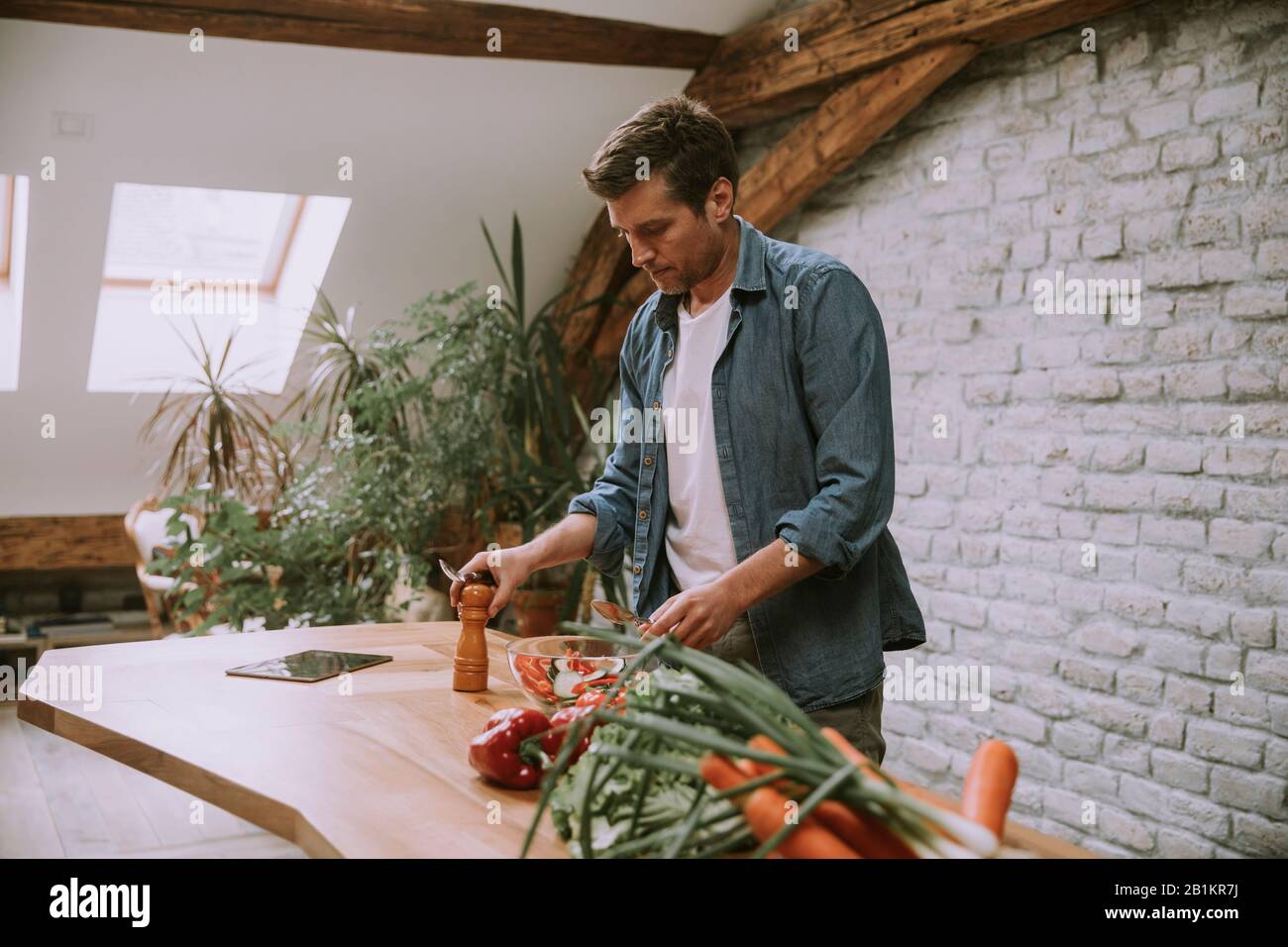 Young man preparing food in the rustic kitchen Stock Photo