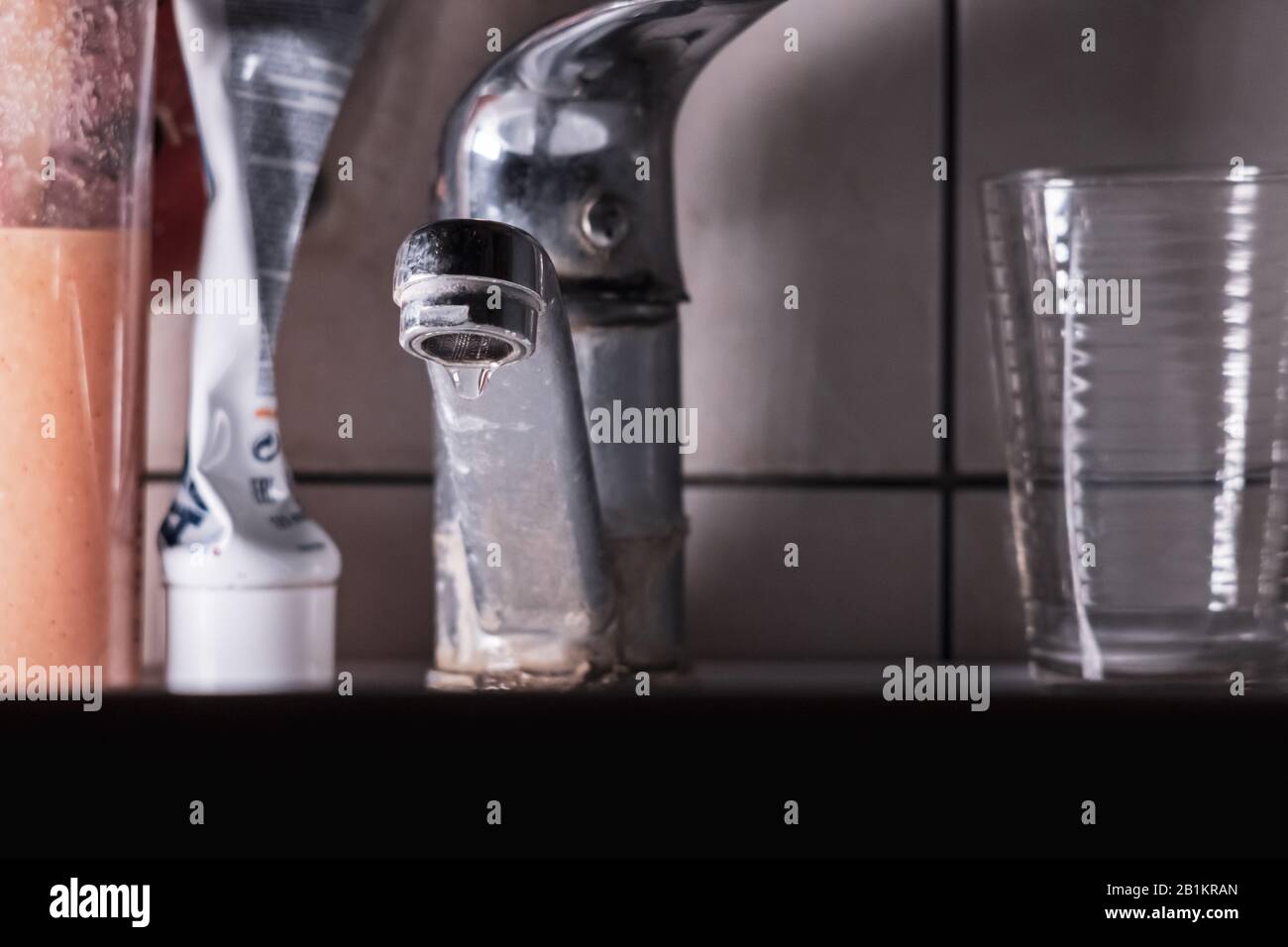 Water tap. Dripping tap in night light. Water drop from old Faucet. Stock Photo