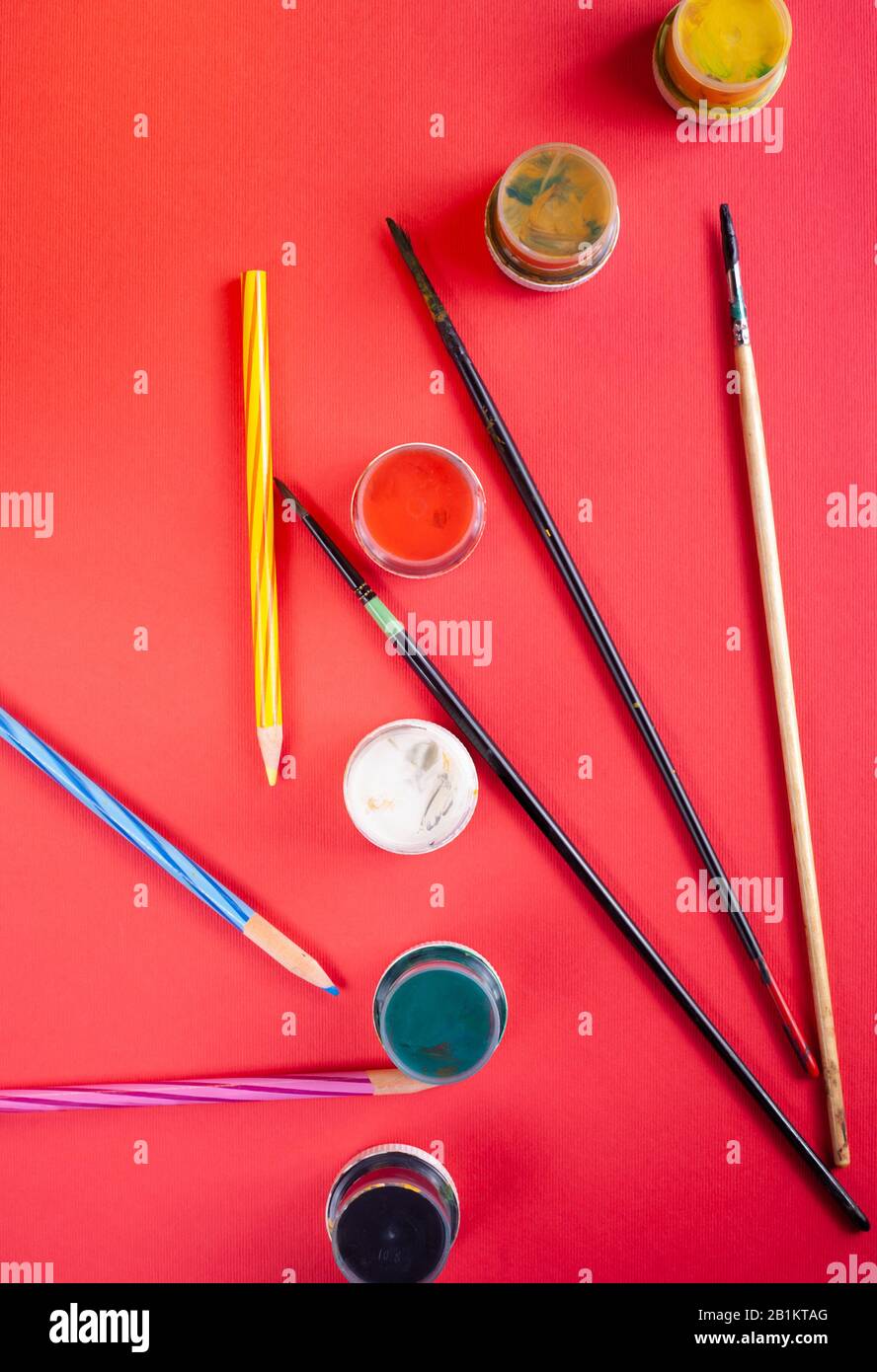 Paint brushes and paints on a red background Stock Photo