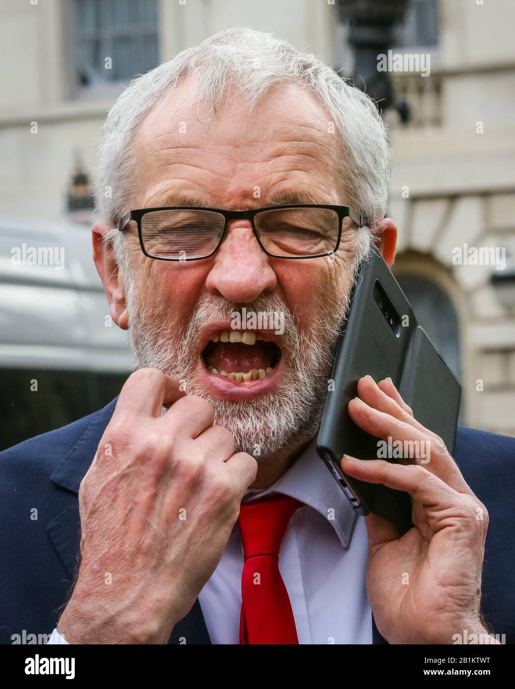 Westminster, London, UK. 26th Feb, 2020. Jeremy Corbyn, pulling a funny face whilst on the phone. Labour Leader Jeremy Corbyn, as well as John Mc Donnell, Dawn Butler, and Labour Chairman Ian Lavery and others speak at a protest organised by the PCS (Public and Commercial Services Union) supporting striking Interserve Workers. Outsourced facilities management workers at the Foreign and Commonwealth Office (FCO) in London began their strike period in November, because Interserve are not willing to recognise PCS. Credit: Imageplotter/Alamy Live News Stock Photo