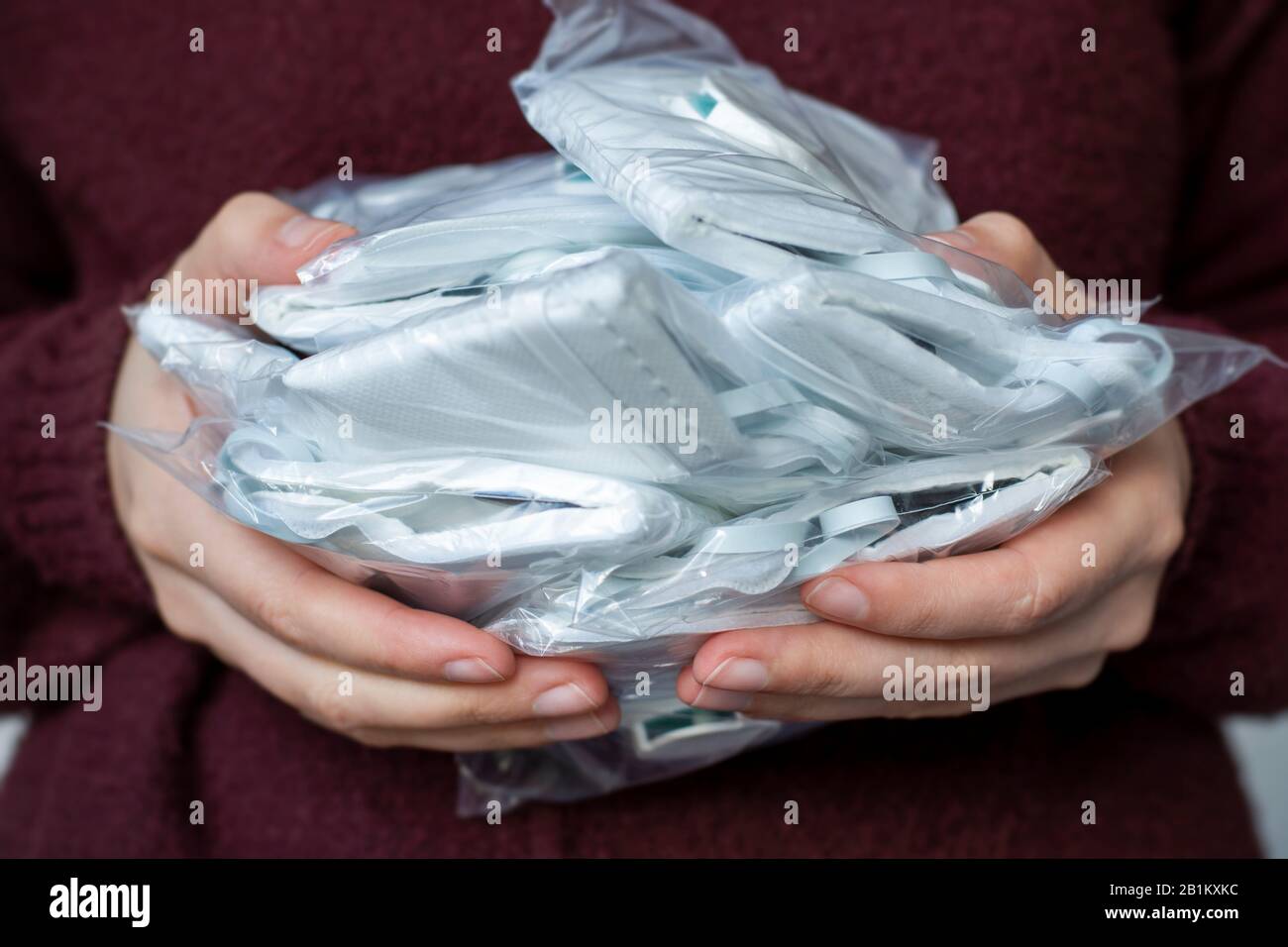 Woman holding a lot of medical face dust filter masks, disposable FFP3 respirators. Coronavirus, air pollution, virus, flu and infectious diseases. Stock Photo