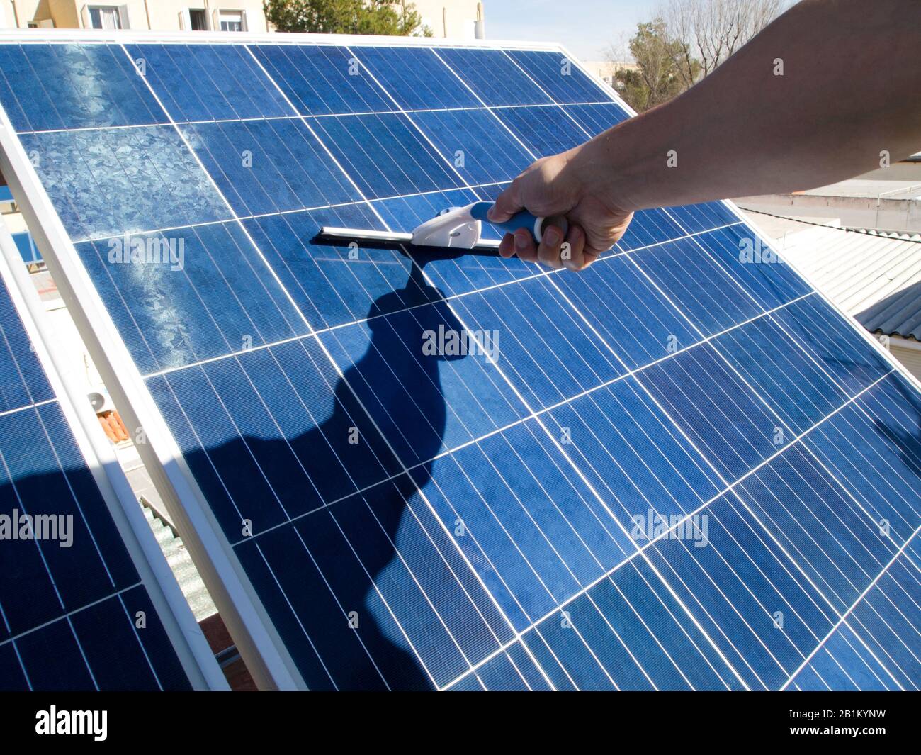 Hand cleaning solar panels with a glass cleaner wiper. Alternative  electricity source, sustainable resource concept Stock Photo - Alamy