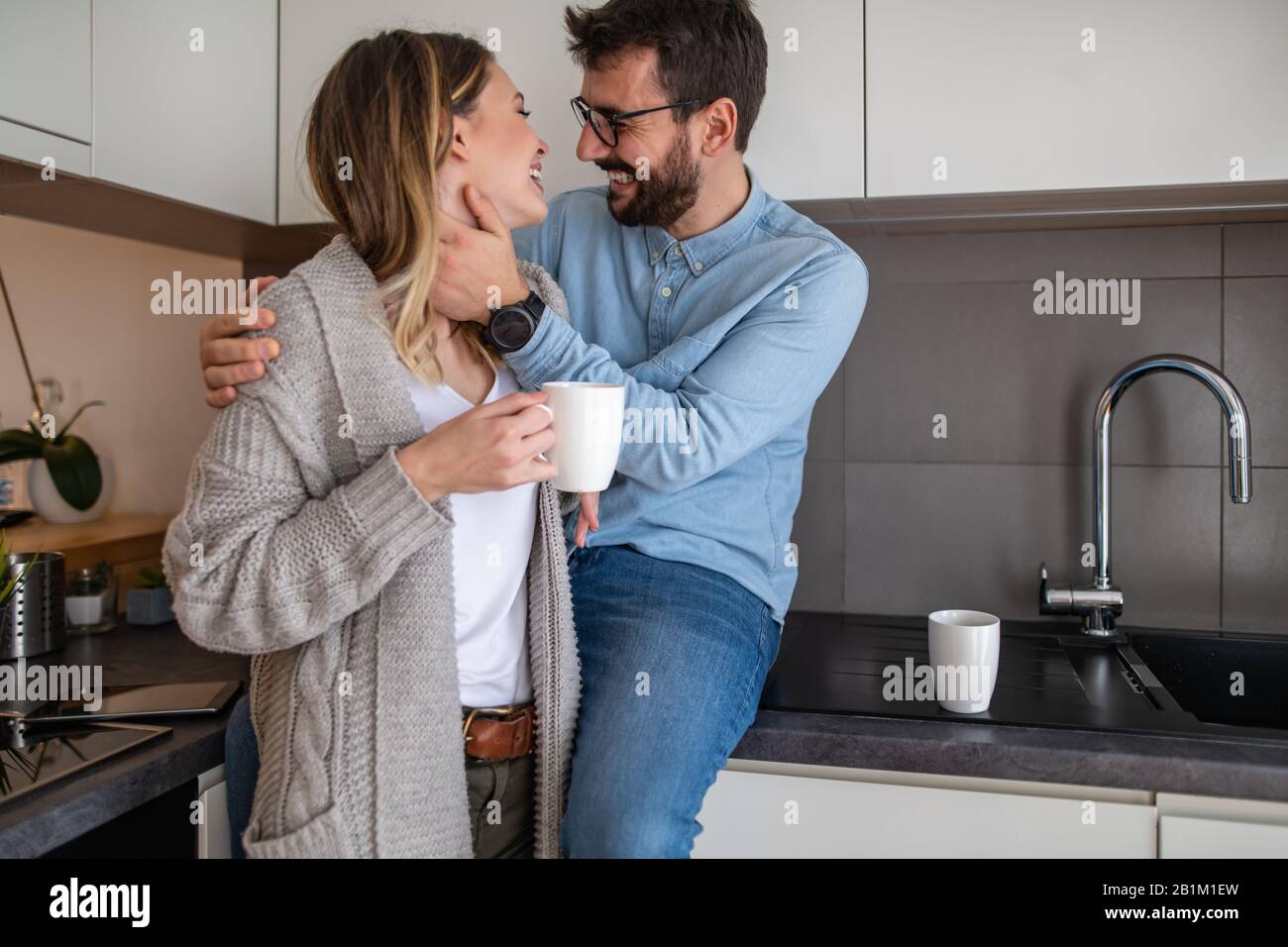 Young couple relaxing at home with cup of coffee.Spending nice time together.Young couple in the morning at home. Stock Photo