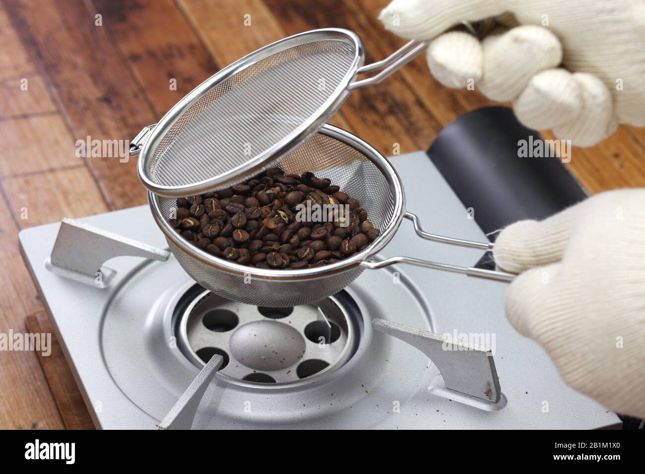 roasting coffee beans process by handy roaster at home; checking roasting  condition of coffee beans Stock Photo - Alamy