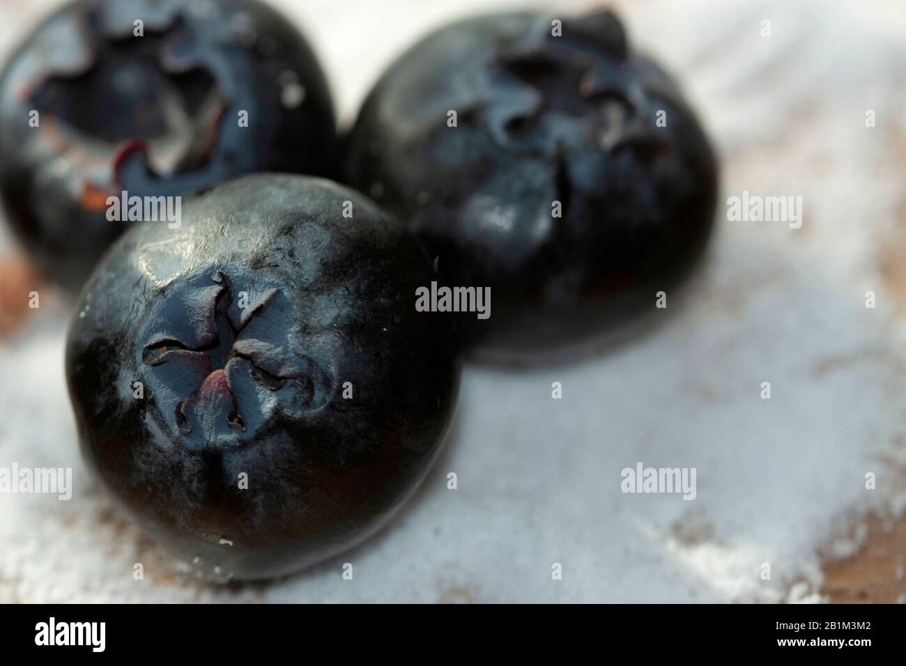 Juicy Blueberries jumbo macro on sugar-free aspartame bed on wood