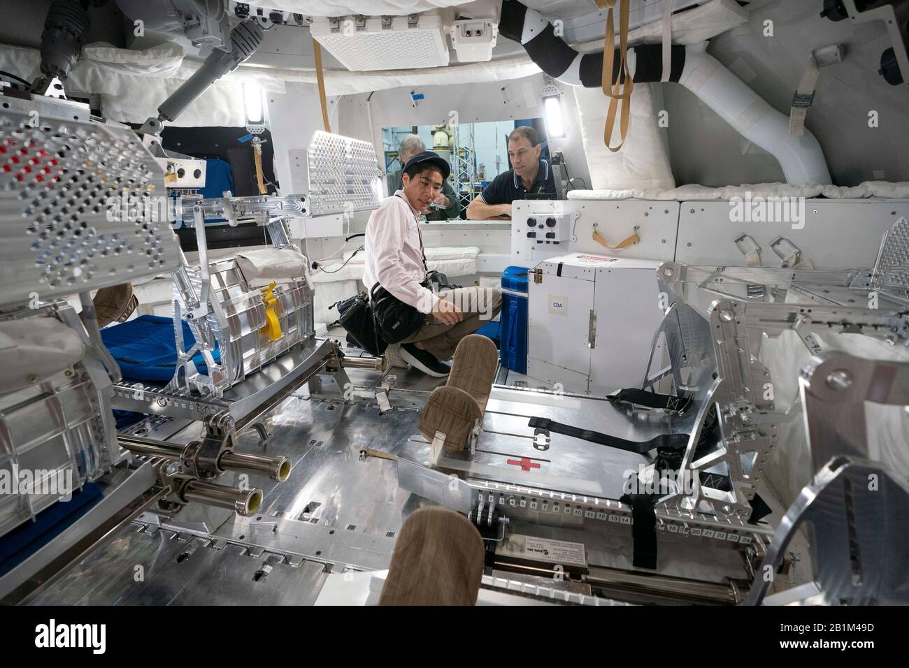 Journalists explore a mock-up of the Orion space capsule at NASA in Houston that will carry four astronauts in future deep space missions to the moon, an asteroid or Mars. Stock Photo