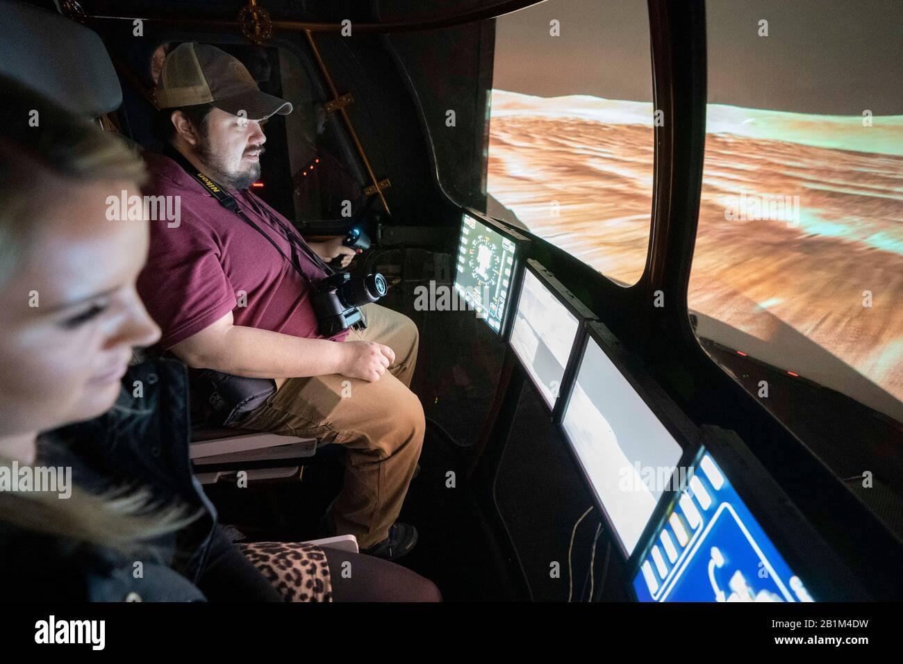 Journalists drive a future two-person Mars Rover simulator in NASA's Systems Engineering Simulator (SES) in Houston. Stock Photo