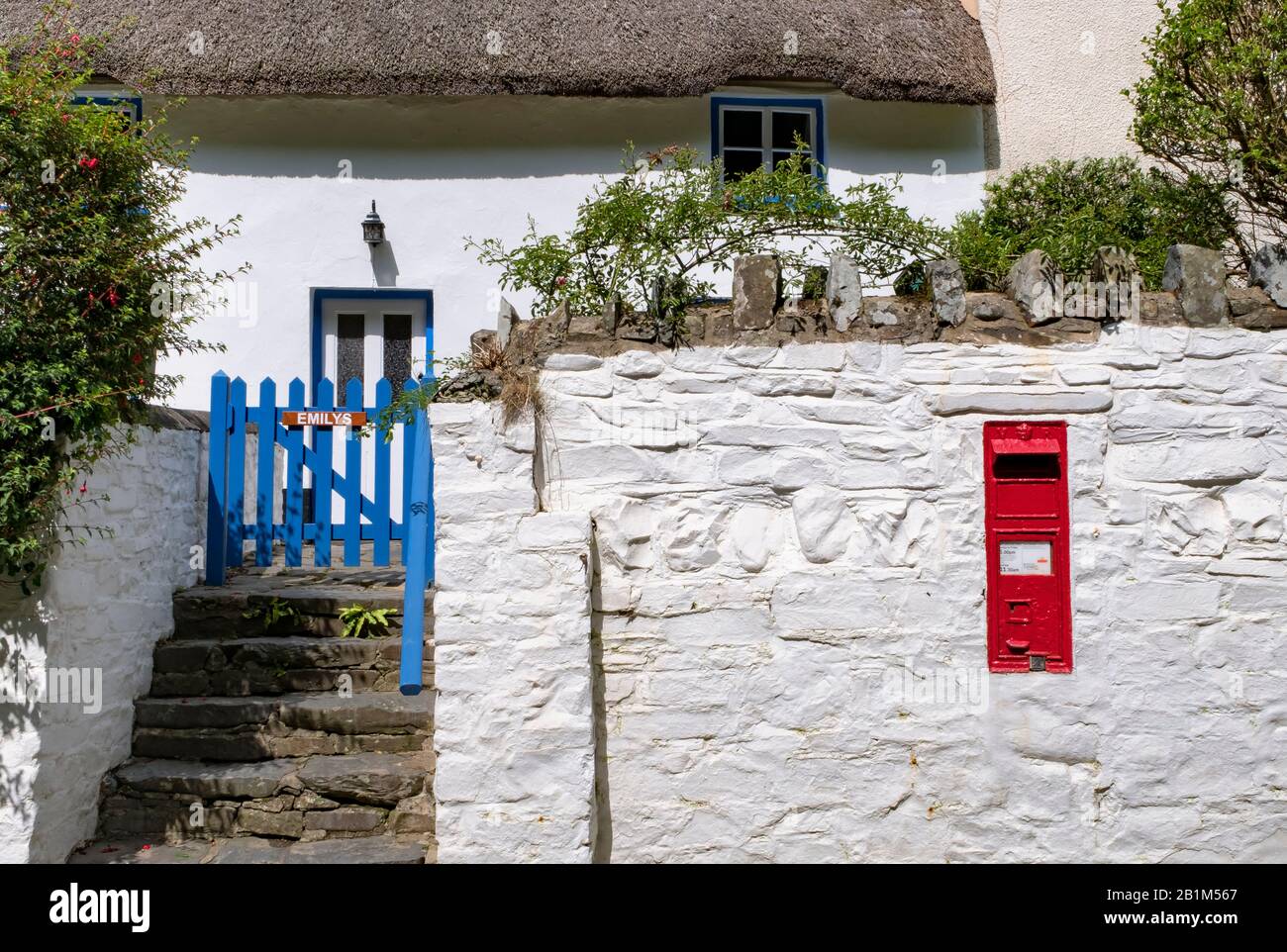 The cottages and holiday cottages at the charming holiday destination of Bucks Mills with a red post box on the wall of the cottage, North Devon Stock Photo