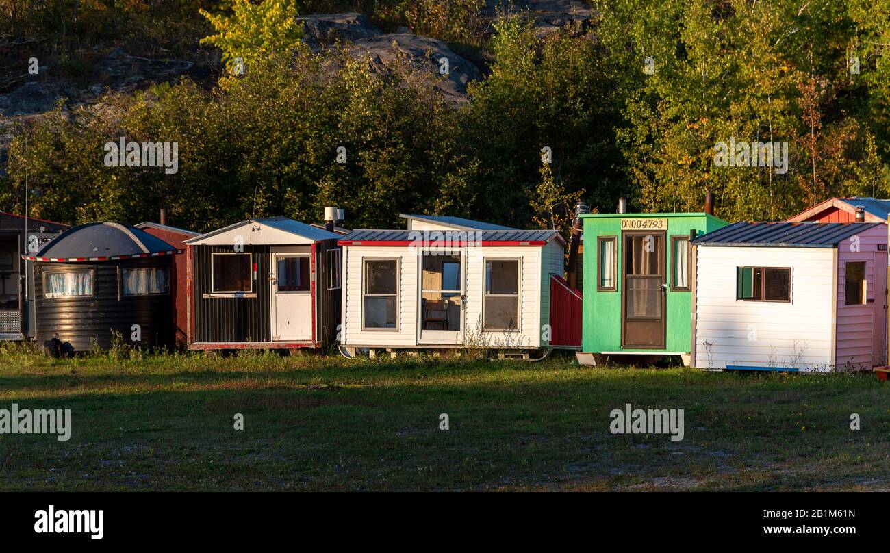Colourful fish huts line up on shore for summer storage. The huts are
