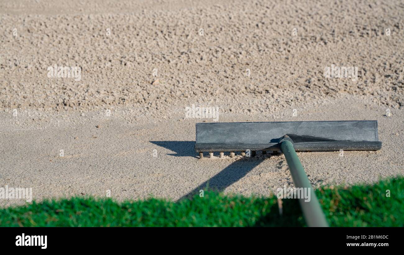Rake in the sand trap on a golf course course Stock Photo - Alamy