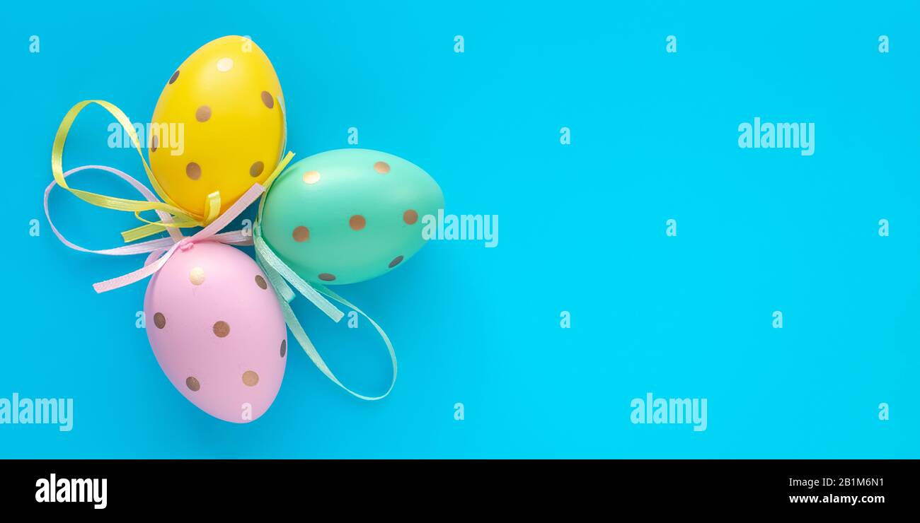 Easter eggs on turquoise background, paschal gift card with text space. Art design decoration. Colorful paschal egg, holiday pattern, mock-up Stock Photo