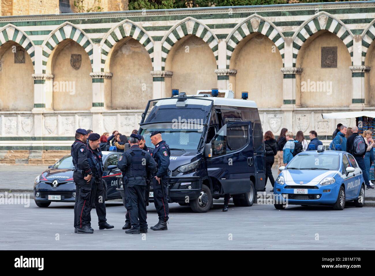 Florence, Italy - April 02 2019: Group of Carabinieri discussing near their vehicles on a town square of the old town. Stock Photo
