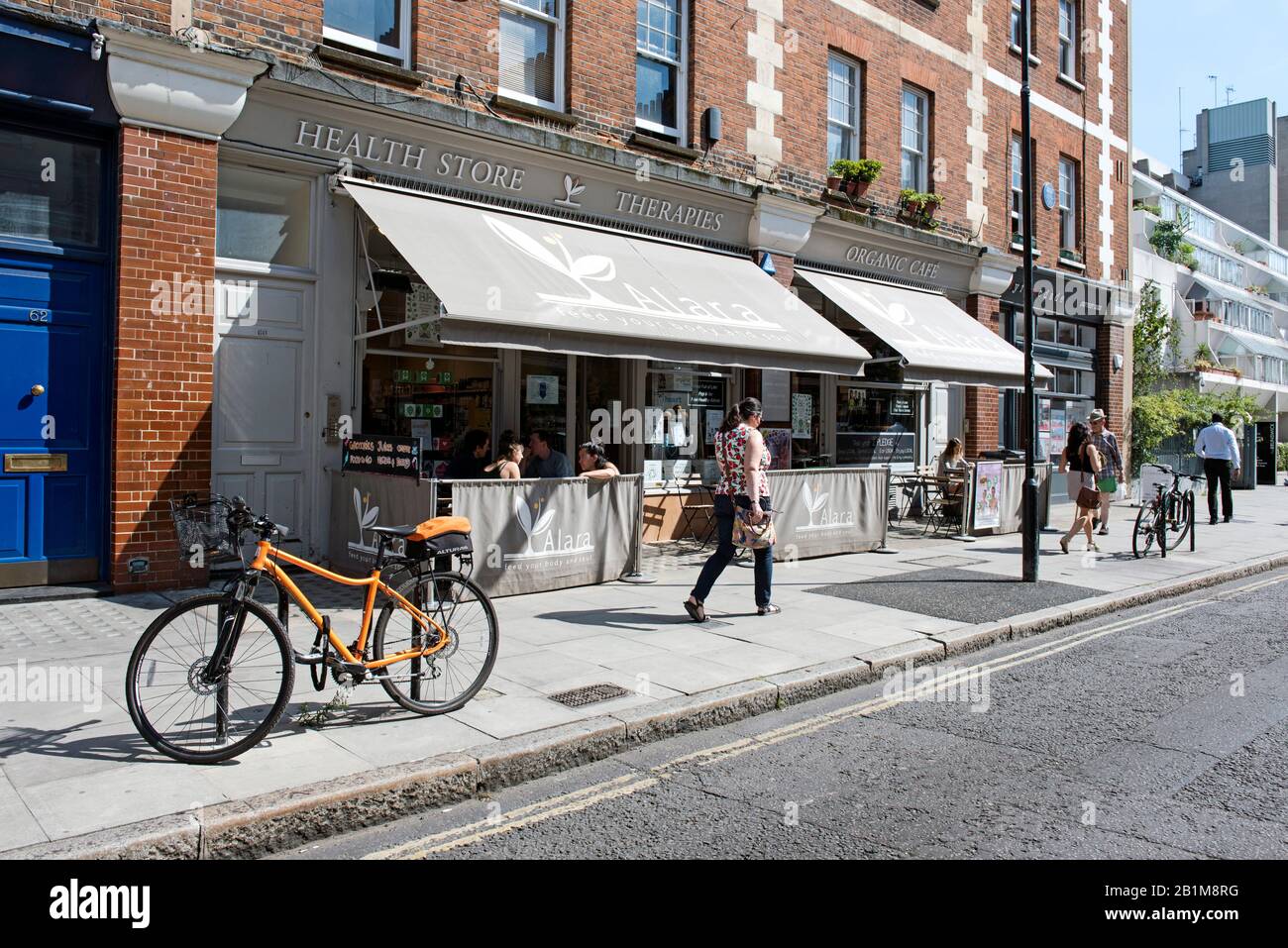 Alara Health Store and Organic Cafe with people walking past, Marchmont Street, Bloomsbury, London Stock Photo