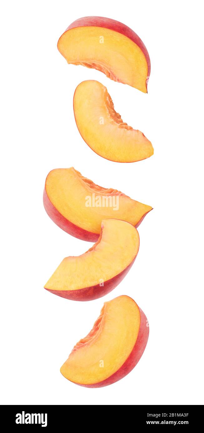 Peach fruit pieces in the air. Five slices of fresh peach falling over white background Stock Photo