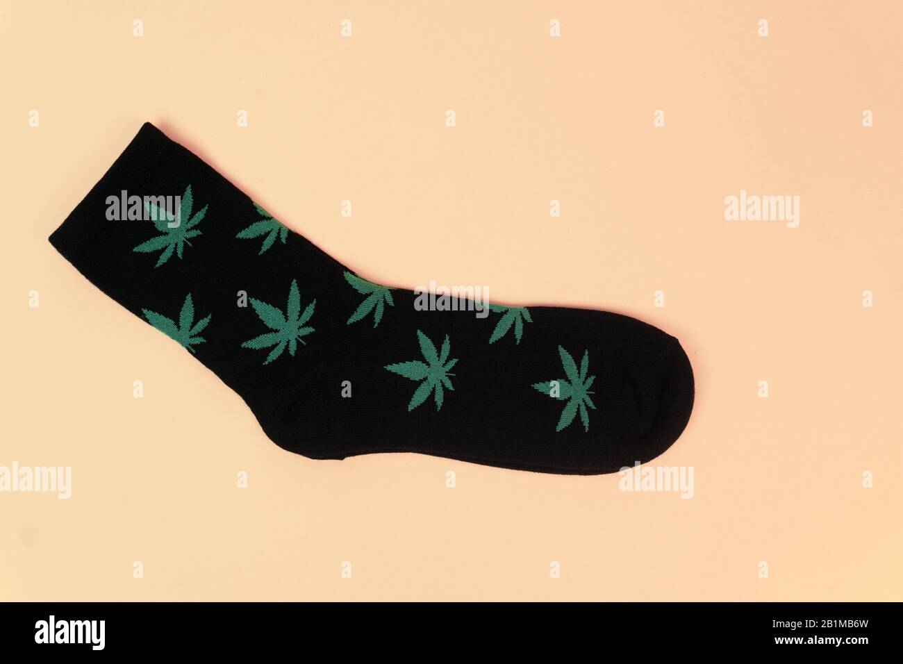 socks with cannabis leaves on yellow background Stock Photo