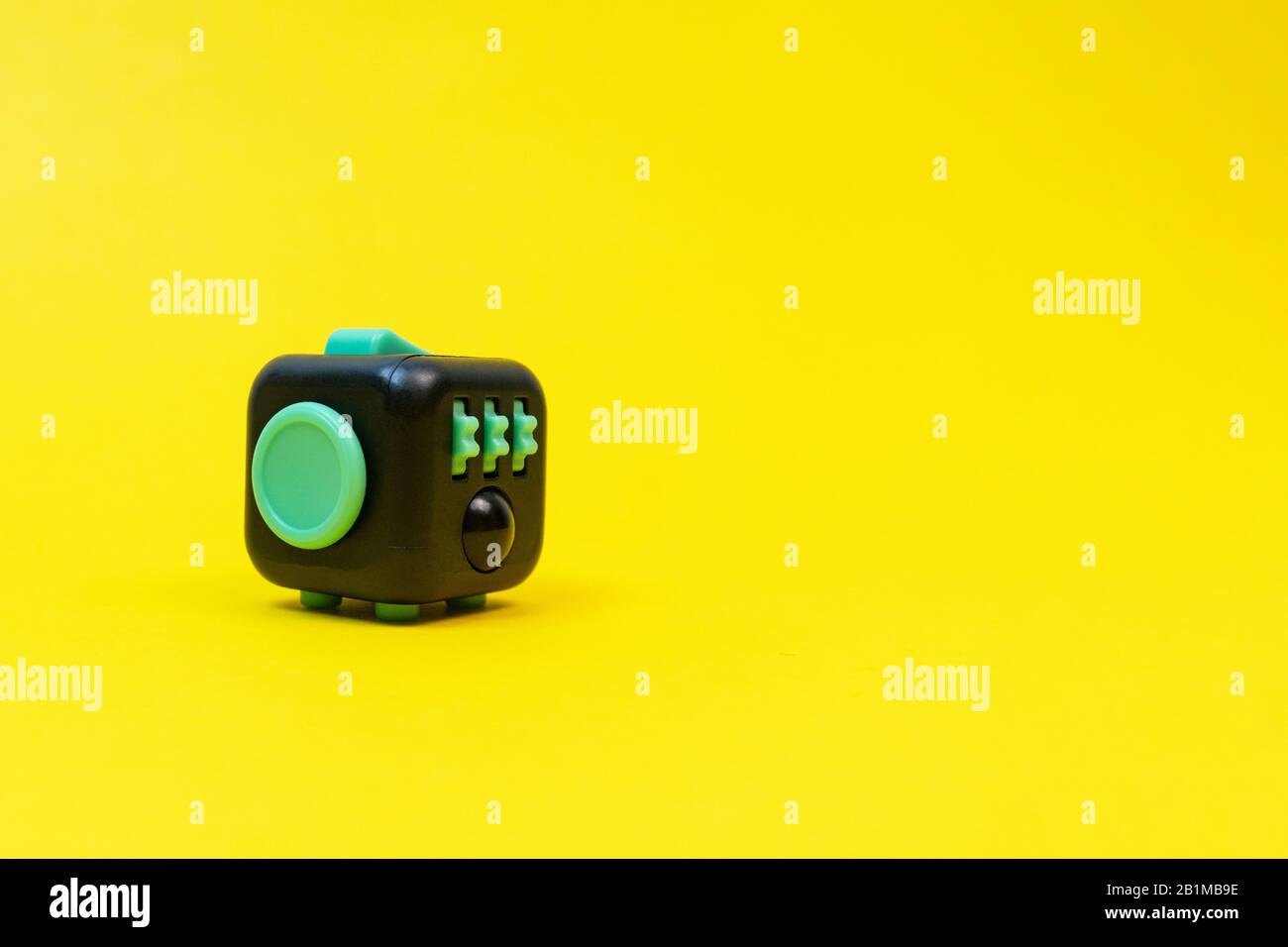 Colorful fingers antistress fidget cube toy in hand on white background.  development of fine motor skills of fingers of children Stock Photo - Alamy