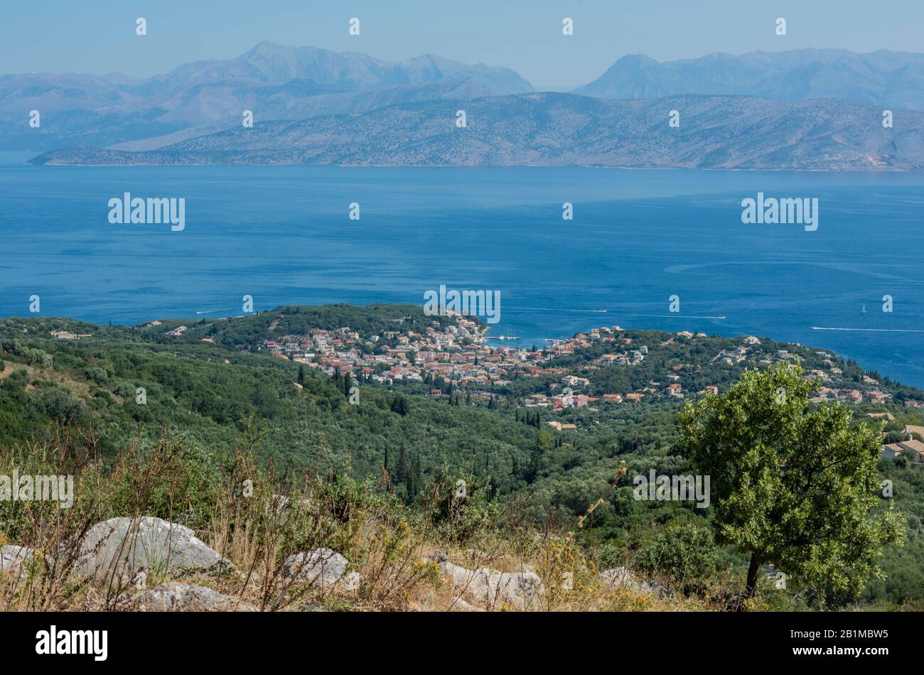 A view from the hills or mountains above the Greek town or village of kassiopi in the Greek mountains. Stock Photo