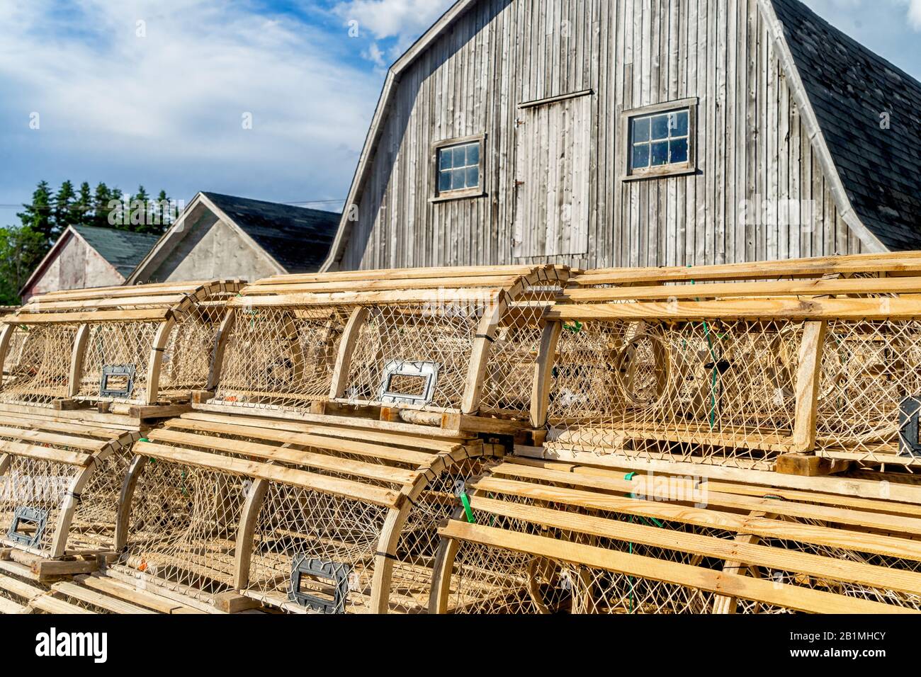Lobster traps piled up against the bait sheds on a wharf in rural