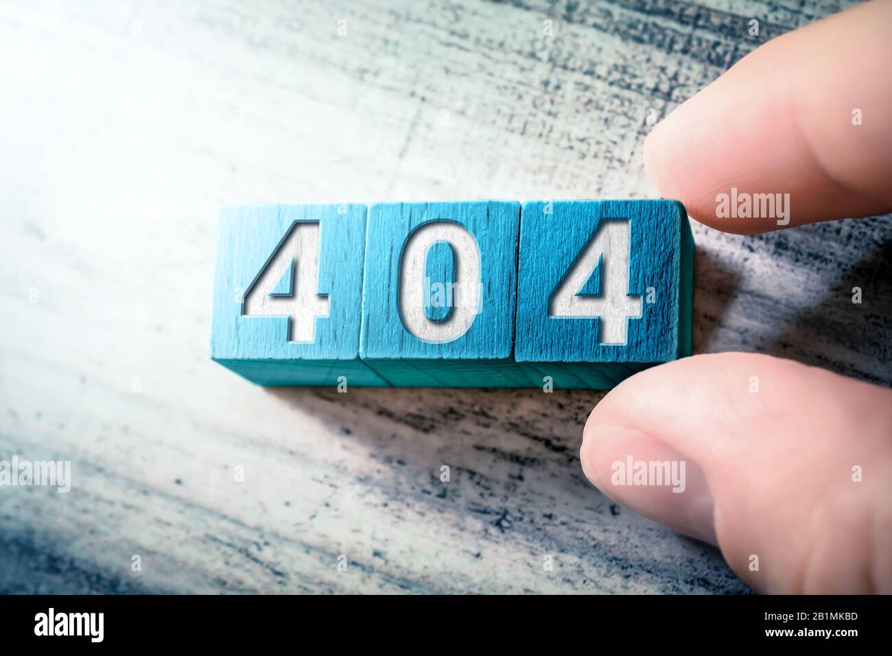 Error Code 404 On Blue Wooden Blocks On A Table, Arranged By A Hand Stock Photo