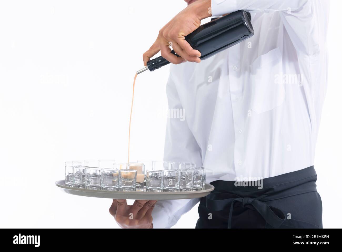 Waiter pouring liquor into glass shots on a tray Stock Photo Alamy