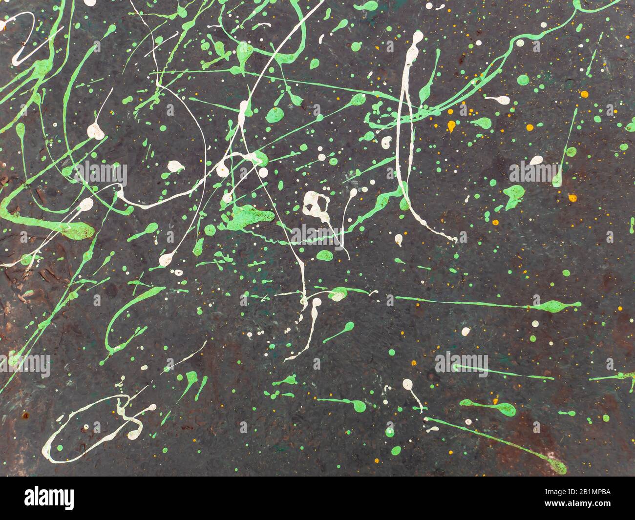 Splashes of colored paint on a black surface. Stock Photo