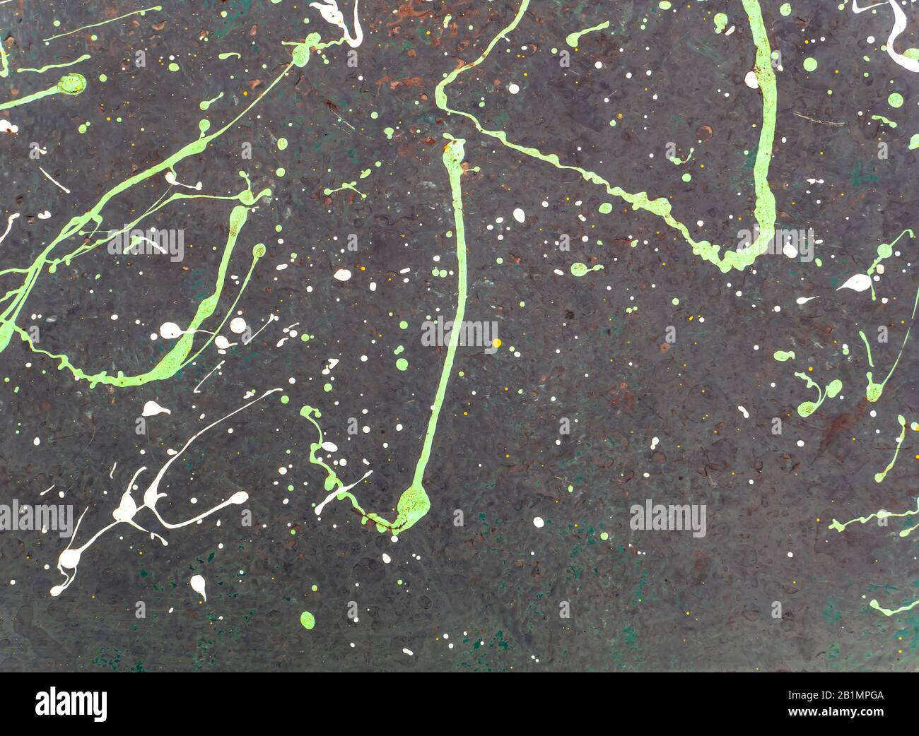 Splashes of colored paint on a black surface. Stock Photo