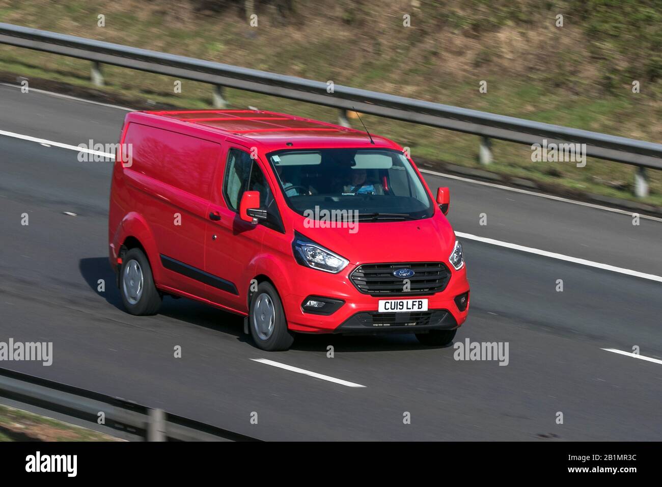 2019 red Ford Transit Custom 320 Trend; driving on the M6 motorway near Preston in Lancashire, UK Stock Photo