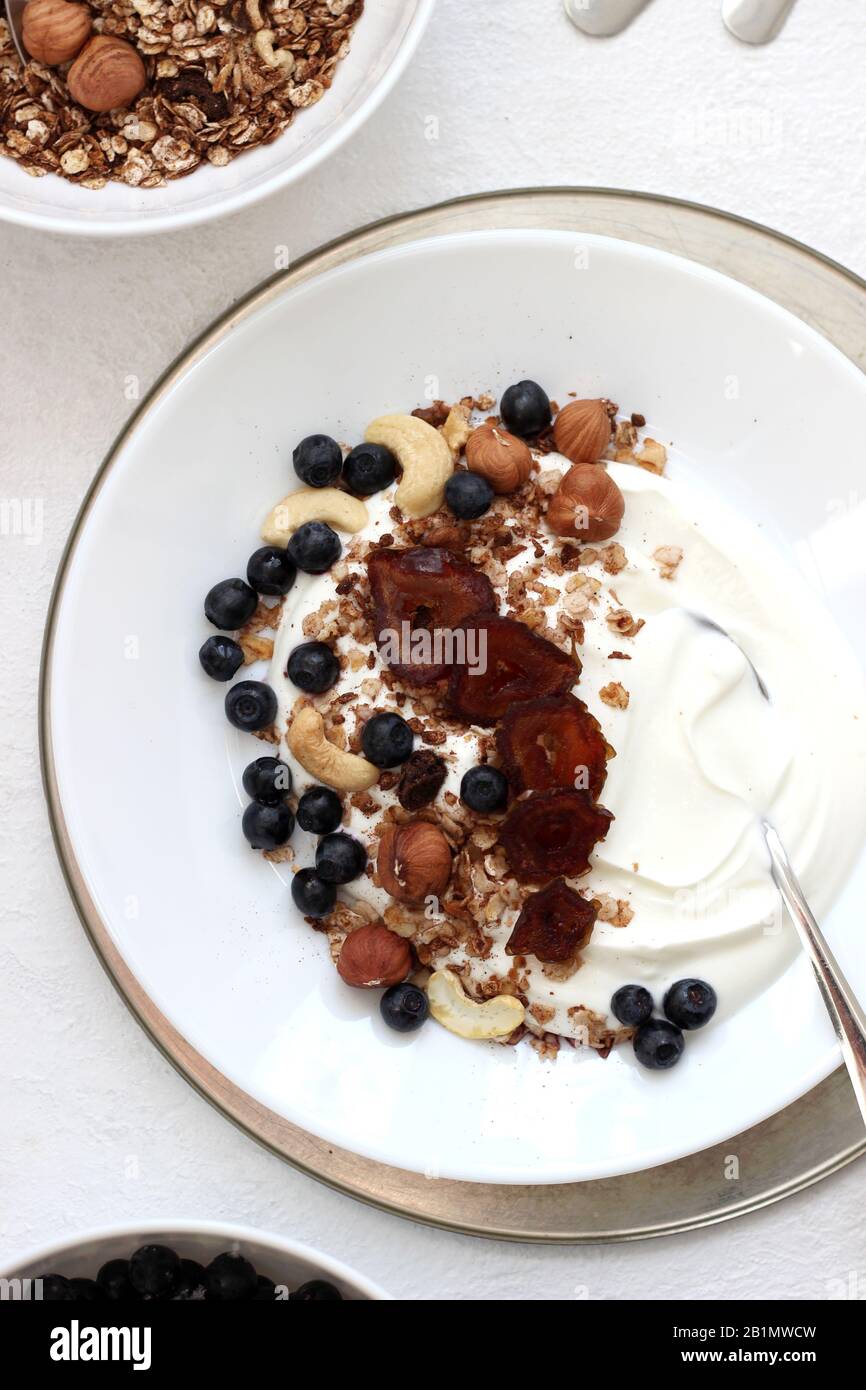 Table Setting of Greek Yogurt with Granola, Nuts and Blueberries