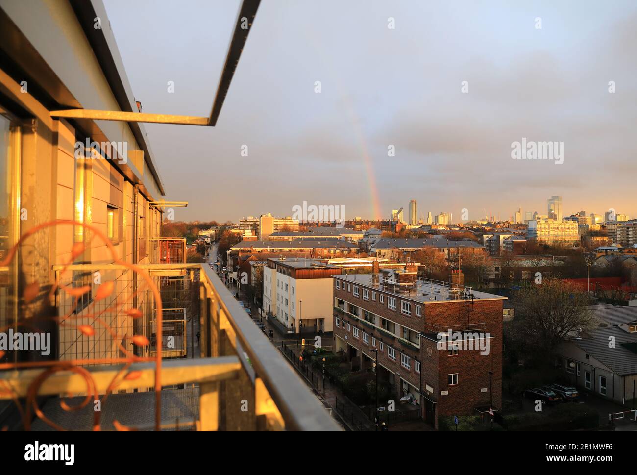A rainbow appears in stormy winter weather over east London and the City, UK Stock Photo