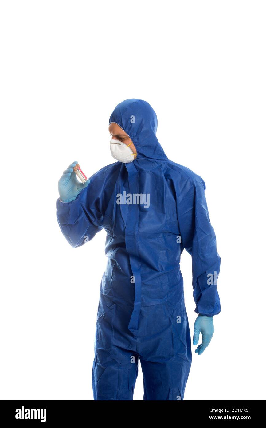Man in protective clothing looking on two sample bottles. Coronavirus test. Stock Photo