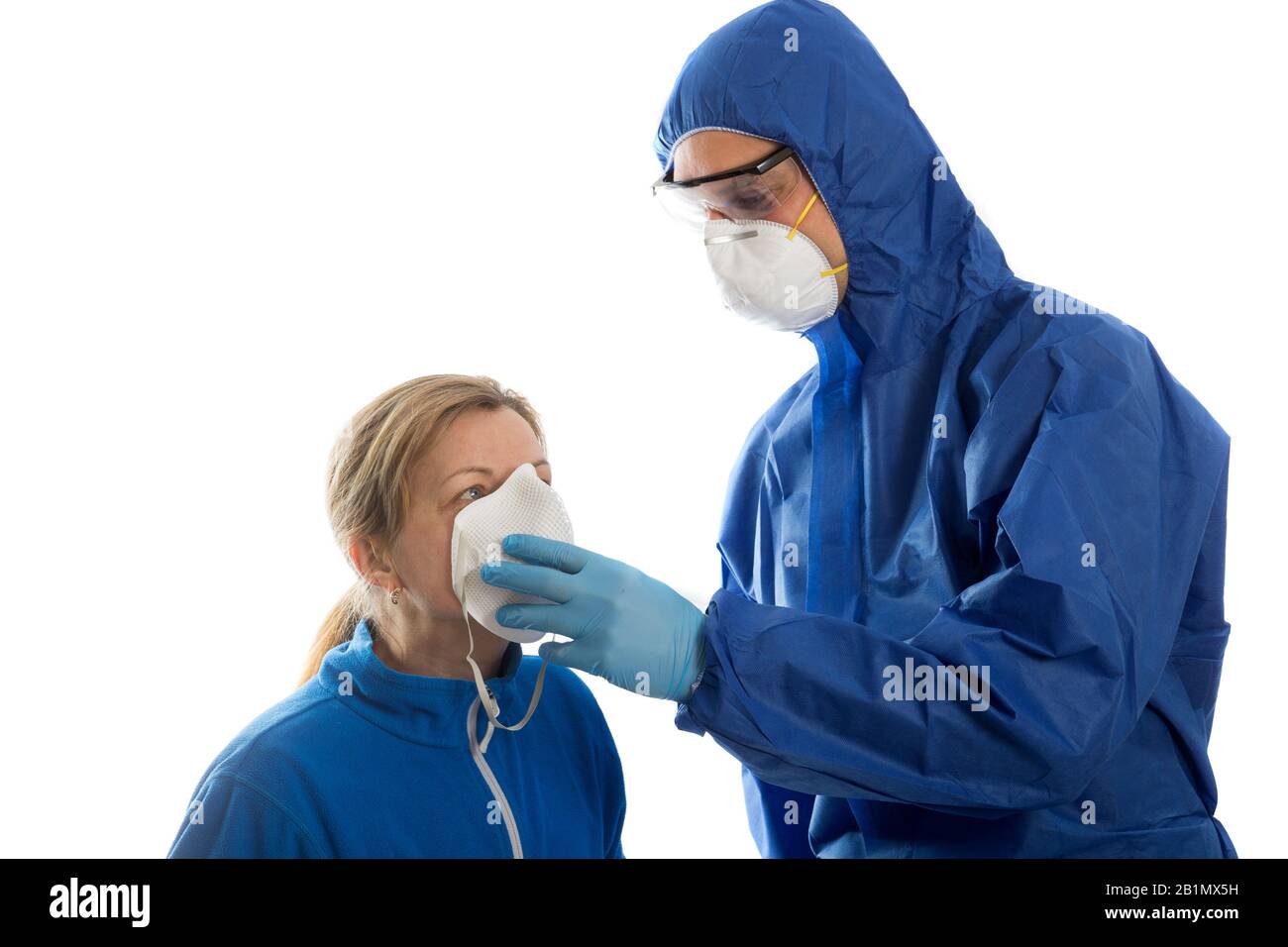 Man in protective clothing give face mask to women. Coronavirus concept. Stock Photo