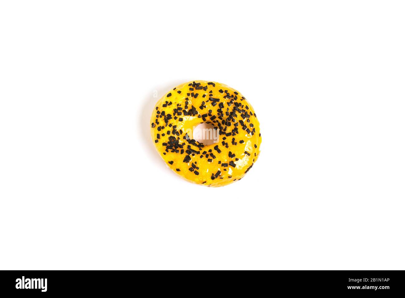 Donut with yellow icing and chocolate chips on a white background with ...