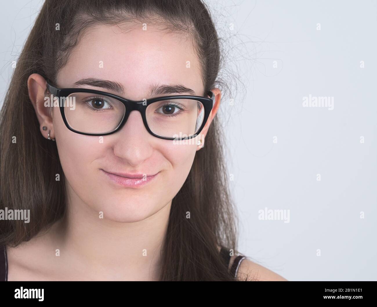 Portrait of a Smiling Bespectacled Long-haired Brunette Teen Girl Stock Photo