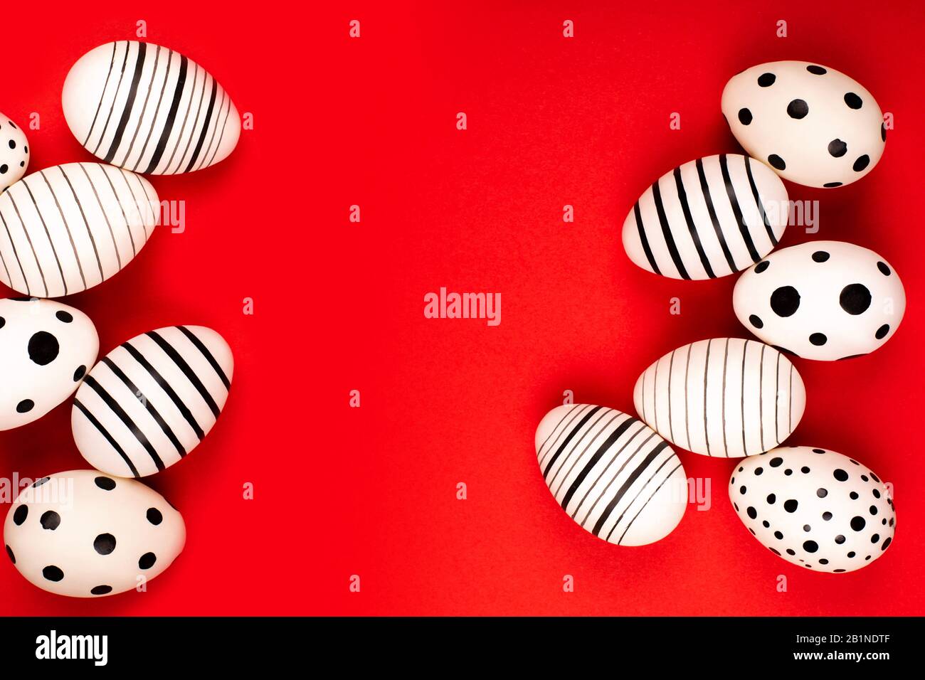 Different graphic hand-painted eggs on bright red background. Easter concept. Place for text. Stock Photo