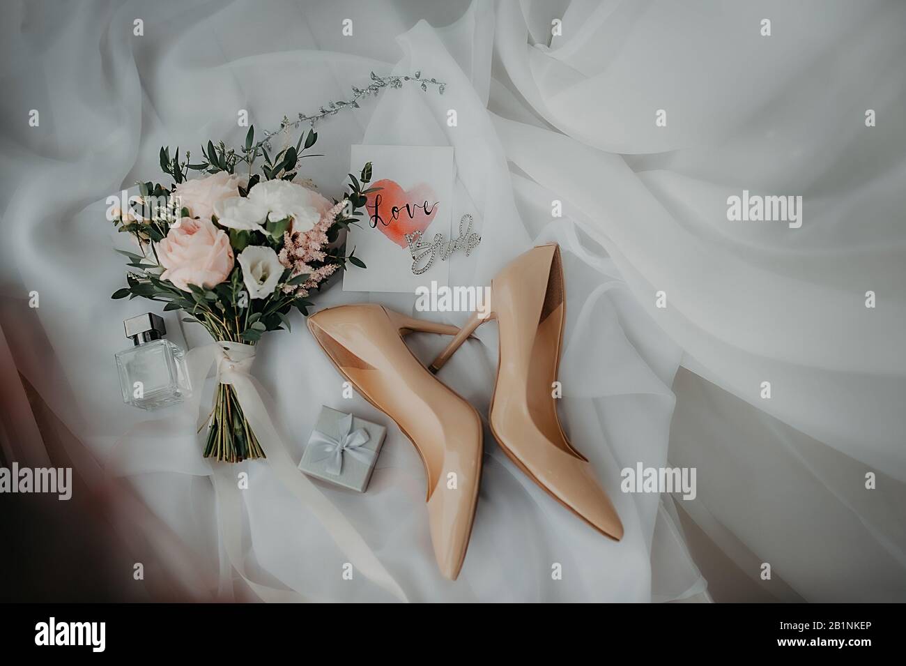 stylish accessories of the bride for dressing and wedding attire, beige patent leather shoes, silver box for rings and a stylish bouquet of peony rose Stock Photo