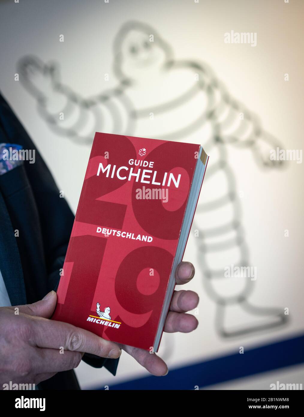 25 February 2020, Hessen, Frankfurt/Main: Ralf Flinkenflügel, Director of the Guide Michelin for Germany and Switzerland, is standing on the sidelines of an interview in the entrance area of the new company headquarters near Frankfurt Airport with last year's edition in his hand. In the gourmet kitchens of Germany the nervousness is increasing these days. Because next Tuesday (3 March) the Michelin stars for this year will be announced in Hamburg. (The face of the person depicted must not be shown) Photo: Frank Rumpenhorst/dpa Stock Photo