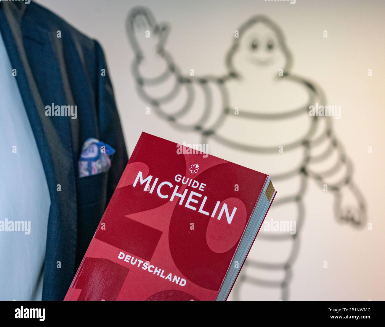 25 February 2020, Hessen, Frankfurt/Main: Ralf Flinkenflügel, Director of the Guide Michelin for Germany and Switzerland, is standing on the sidelines of an interview in the entrance area of the new company headquarters near Frankfurt Airport with last year's edition in his hand. In the gourmet kitchens of Germany the nervousness is increasing these days. Because next Tuesday (3 March) the Michelin stars for this year will be announced in Hamburg. (The face of the person depicted must not be shown) Photo: Frank Rumpenhorst/dpa Stock Photo